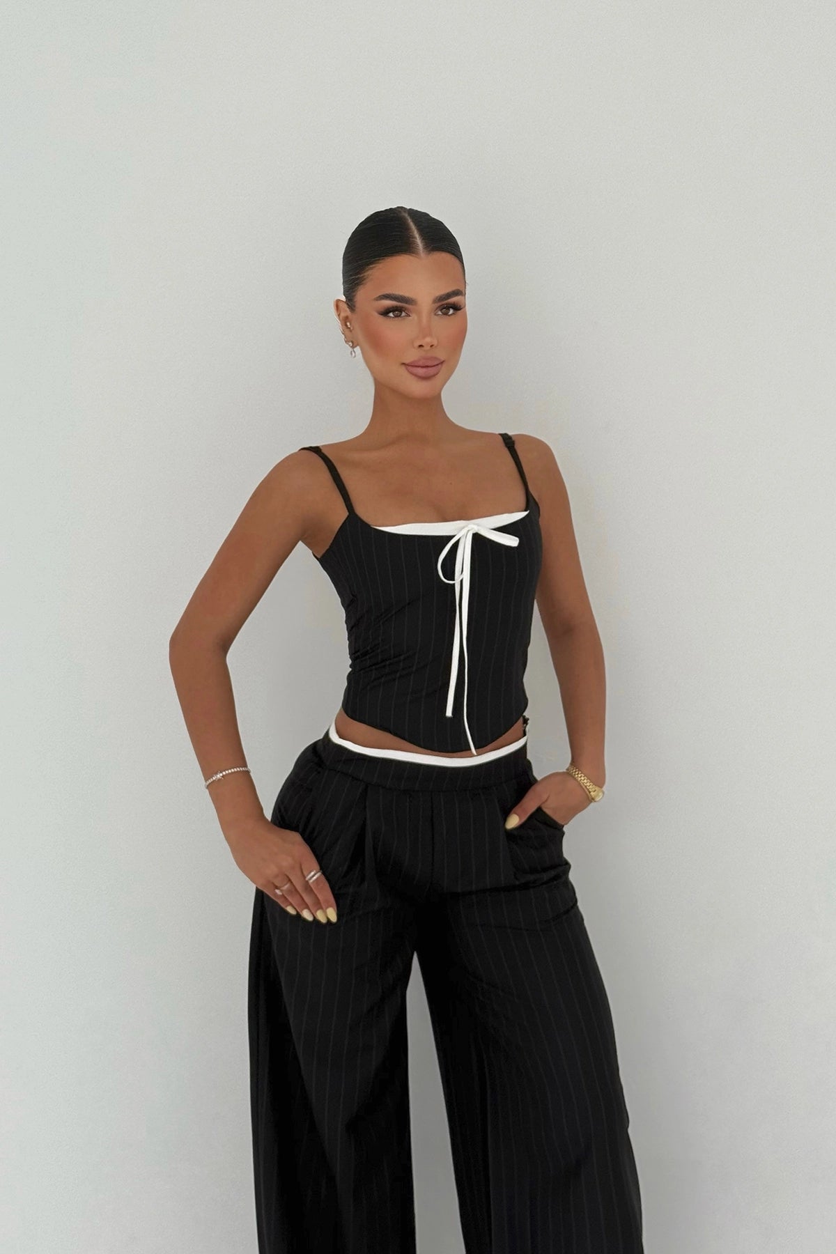 Side view of pinstripe cut-out set showing fitted corset and wide-leg pants.