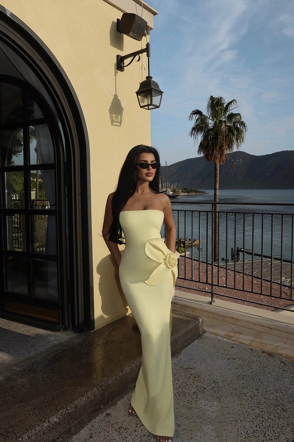 Model wearing yellow strapless evening gown with rose detail at hip – LARYVOE fashion

