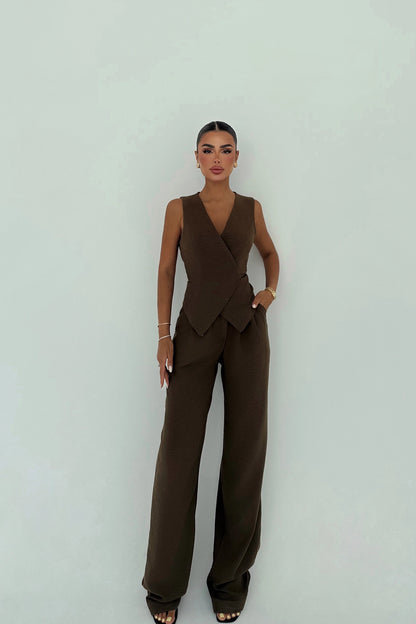 Woman wearing mocha brown sleeveless wrap vest with matching wide-leg trousers.