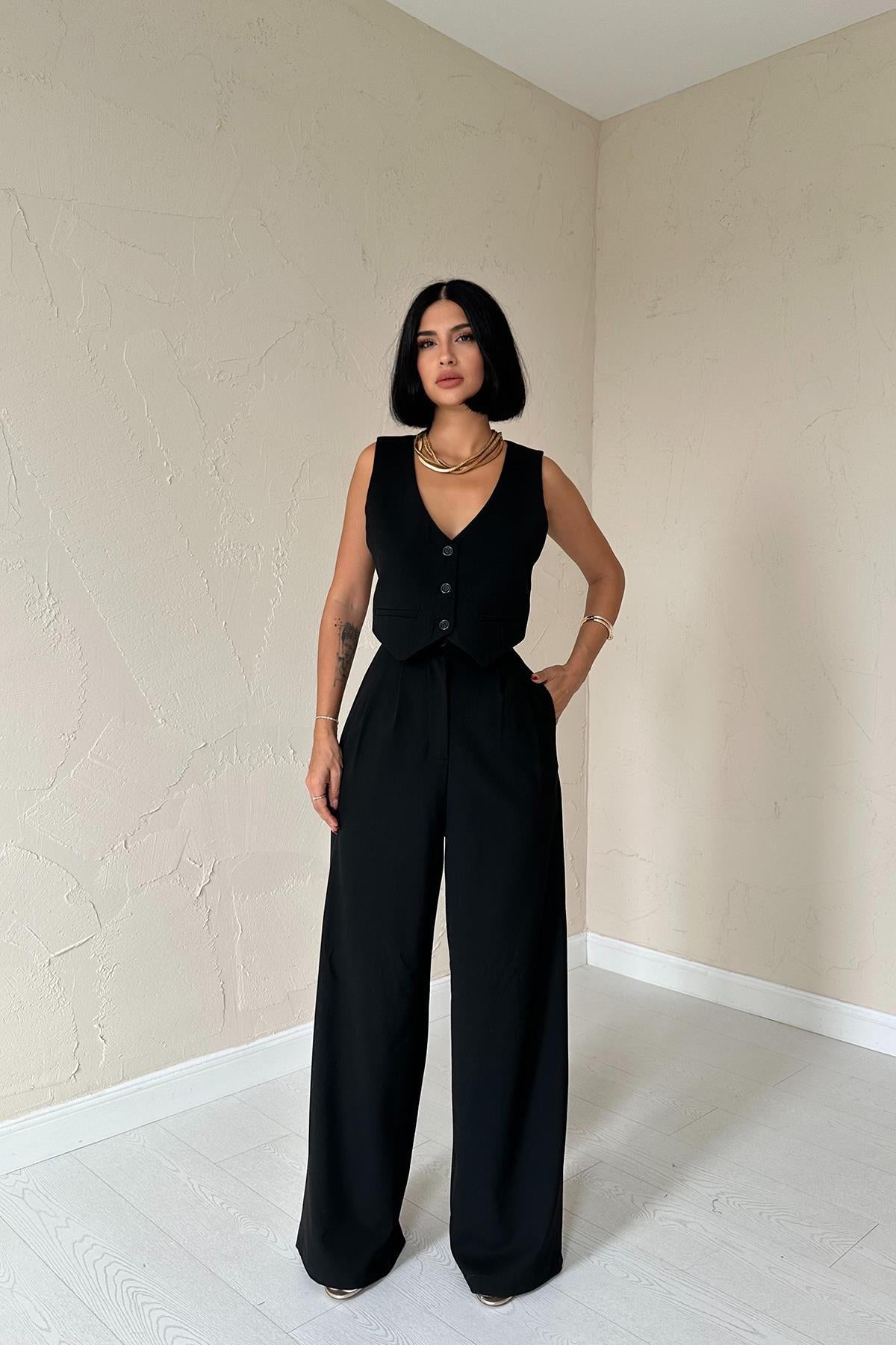 Woman in tailored black vest and wide-leg trousers from trio suit set.