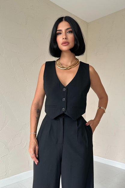 Close-up of black tailored vest with button detail from trio set.