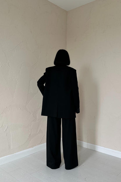Back view of tailored black blazer and trousers from women’s trio set.