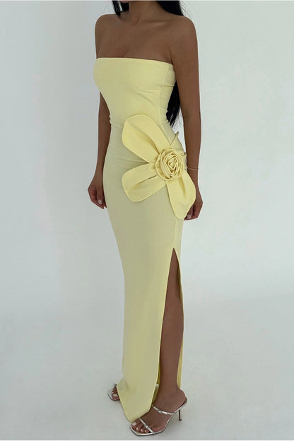 Yellow strapless dress with a large floral embellishment on a white background