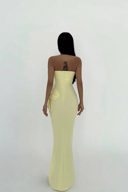 back view of woman wearing a strapless yellow evening gown on a white background