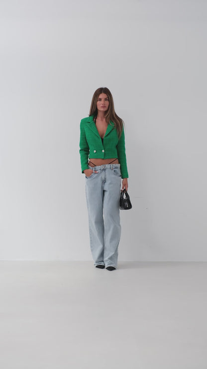 Model walking towards the camera wearing emerald green cropped bouclé blazer – chic women’s tailored jacket from LARYVOE.